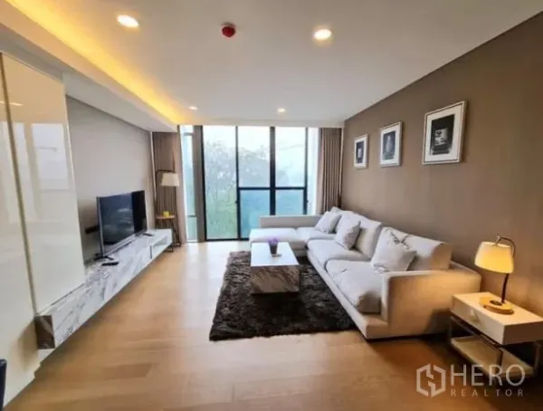 公寓 出租在Khlong Toei, Bangkok - 宽敞客厅，落地窗、沙发与电视柜，天花暗藏灯光