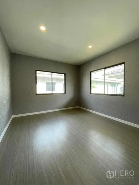 บ้าน ขายในNuea Khlong, Krabi - ห้องนอนเปล่าผนังสีเทา มีหน้าต่างสองบานและไฟดาวน์ไลท์