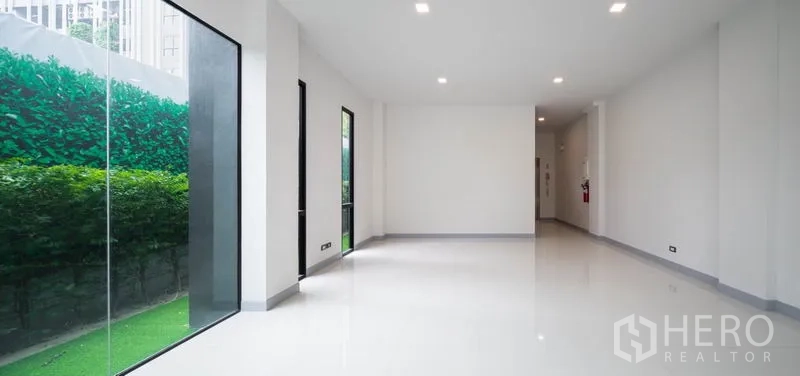 สำนักงานที่บ้าน ให้เช่าในBang Rak, Bangkok - ภายในแบบโอเพ่นสเปซ โทนขาว หน้าต่างสูงจรดเพดานมองเห็นแนวพุ่มไม้สีเขียว