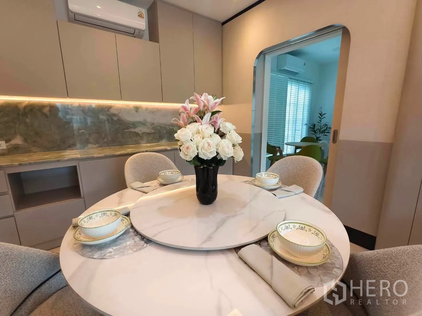 Detached House for rent in Bang Phli, Samut Prakan - Elegant dining room with round marble table, floral centerpiece, and cabinetry.
