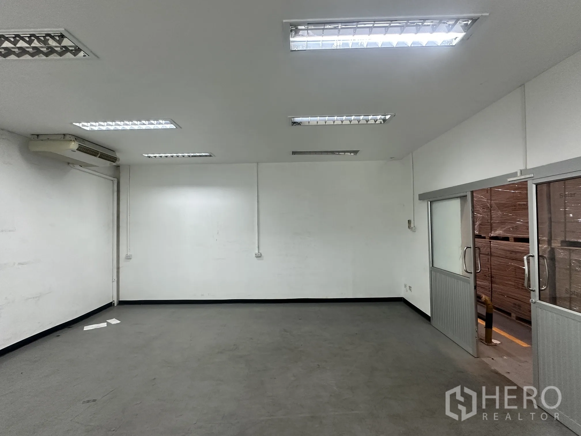 Warehouse for rent in Lat Krabang, Bangkok - Enclosed office room with fluorescent lighting and sliding doors beside the warehouse.