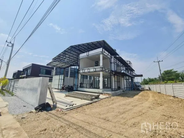 Warehouse for rent in Bang Len, Nakhon Pathom - Two-story steel-frame warehouse with covered loading bay, wide driveway and perimeter walls under a clear sky.