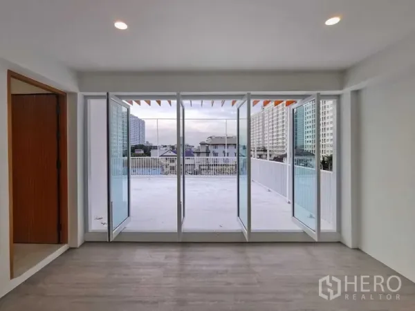 Home Office for sale in Suan Luang, Bangkok - Bedroom or office opening to an expansive terrace through sliding glass doors.