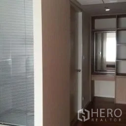 Condominium for rent in Sathon, Bangkok - Hallway with glass partition, built-in shelving and a vanity nook inside a contemporary condominium.
