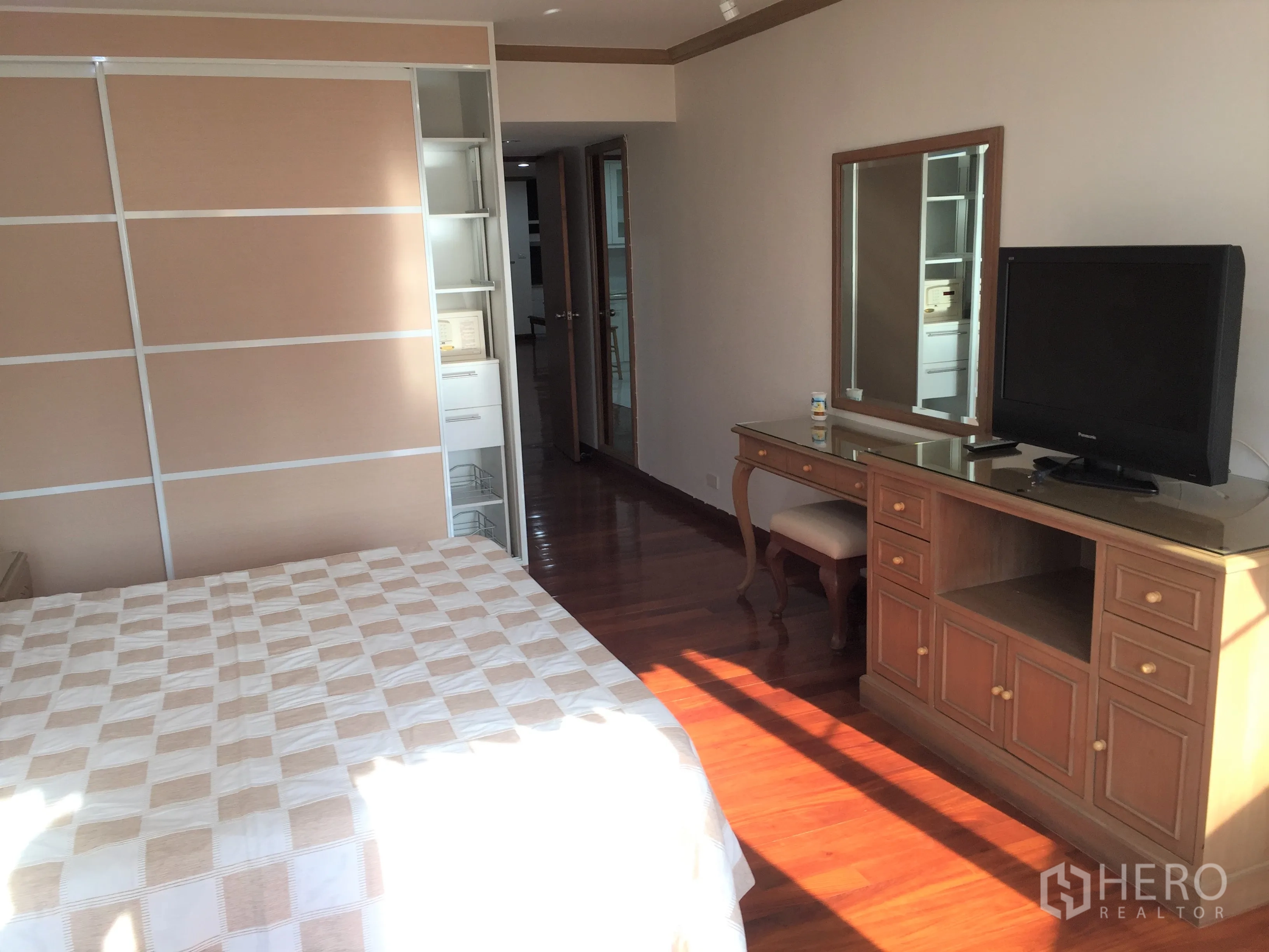 Condominium for rent in Watthana, Bangkok - Bright bedroom with wooden floors, sliding wardrobe and dressing table with TV.