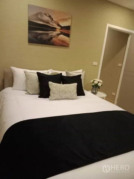 ทาวน์เฮาส์ ให้เช่าหรือขายในSuan Luang, Bangkok - ห้องนอนพร้อมชุดเครื่องนอนสีขาว ผ้าคลุมเตียงสีดำ และประตูทางเข้าสุขภัณฑ์