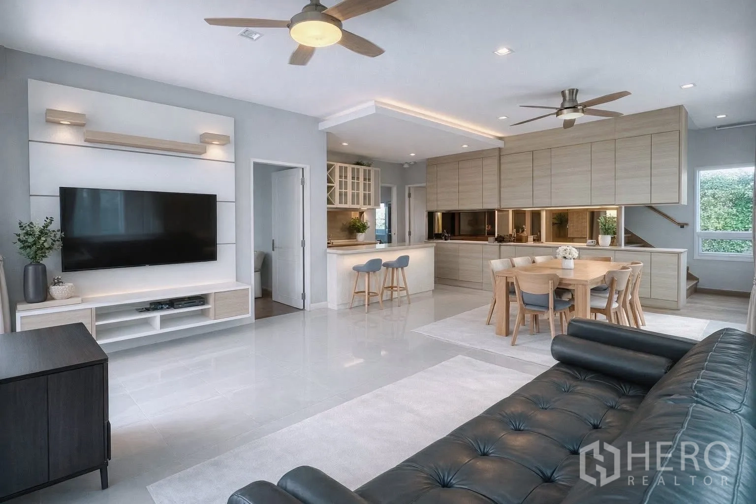 Detached House for rent or sale in Bang Phli, Samut Prakan - Open-plan living and dining area with TV wall, breakfast counter, and ceiling fans.