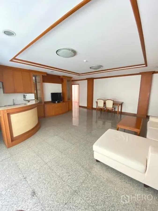 อพาร์ทเมนท์ ให้เช่าในWatthana, Bangkok - ห้องนั่งเล่นโปร่งสว่าง พื้นที่เปิดโล่ง โซฟาสีครีม ครัวเคาน์เตอร์โค้ง ตู้บิลท์อินและโต๊ะทานข้าว