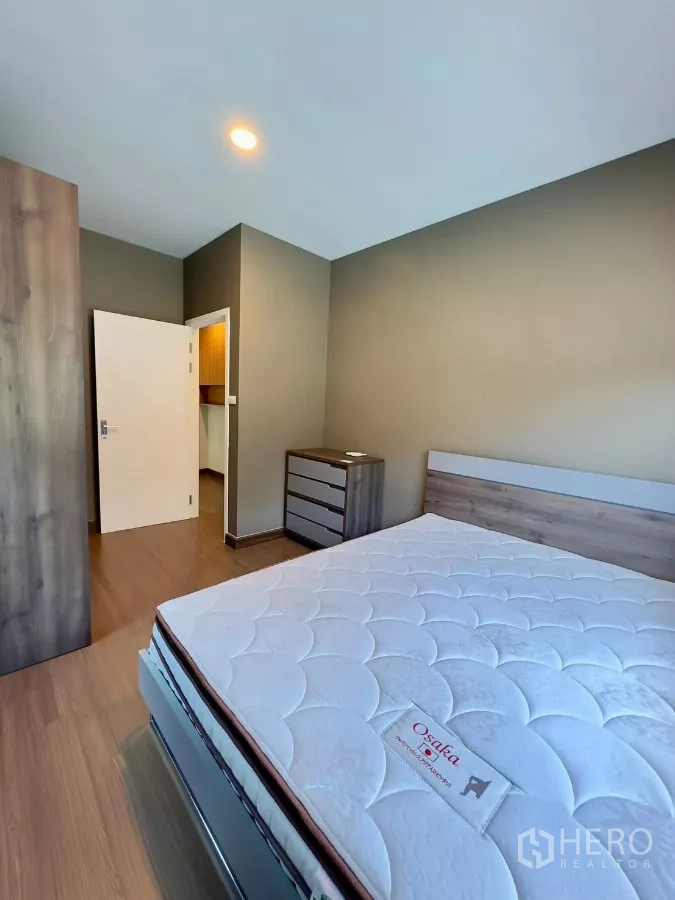 独立式住宅 出租在Samut Prakan - 卧室角度展示床垫、衣柜与走廊门口。