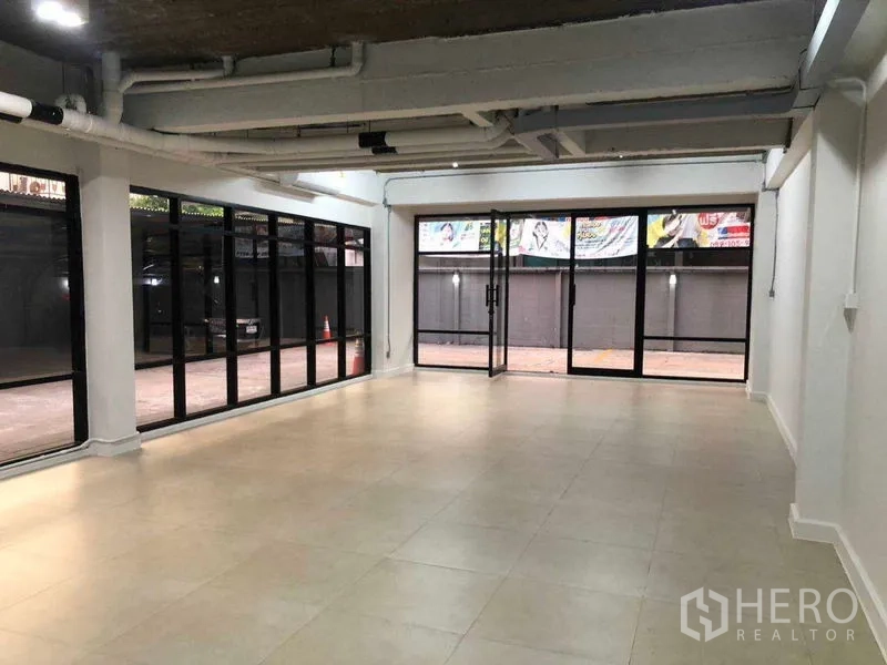 办公空间 出租在Phaya Thai, Bangkok - 开放式办公室，环绕玻璃墙面，面向庭院。