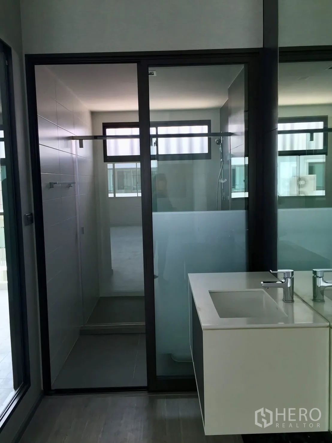 Townhouse for rent in Lat Phrao, Bangkok - Bathroom with glass shower enclosure and modern vanity.