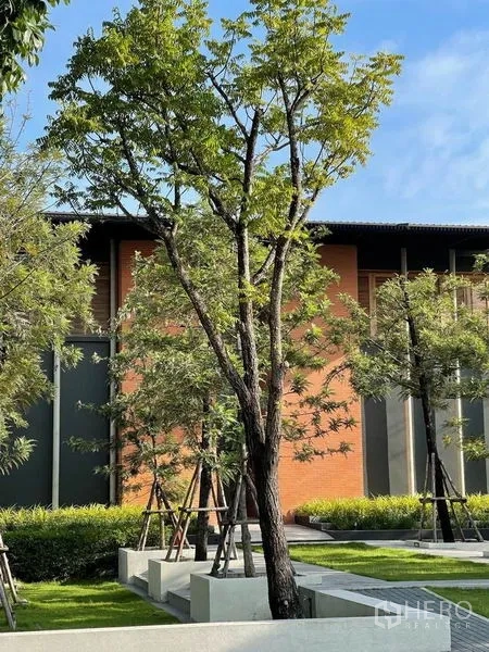 บ้าน ขายในSai Mai, Bangkok - สวนส่วนกลางจัดภูมิทัศน์ มีต้นไม้ใหญ่และอาคารคลับเฮ้าส์อิฐและกระจก