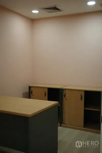 Office Space for rent in Bang Na, Bangkok - Compact private room with a desk, storage cabinets and recessed ceiling lights.
