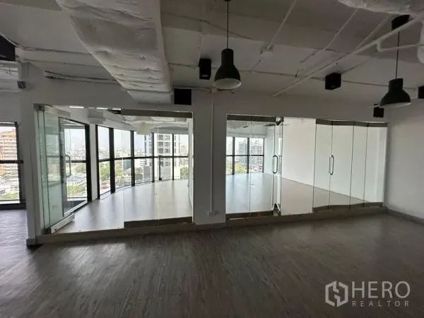 Office Space for rent - Two glass-walled meeting rooms facing skyline views and natural light.