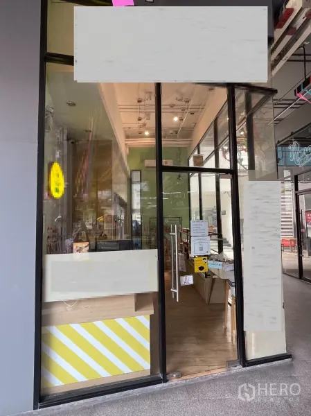 零售空间 出租在Khlong Toei, Bangkok - 玻璃入口门，紧凑零售空间，高挑天花与木地板。