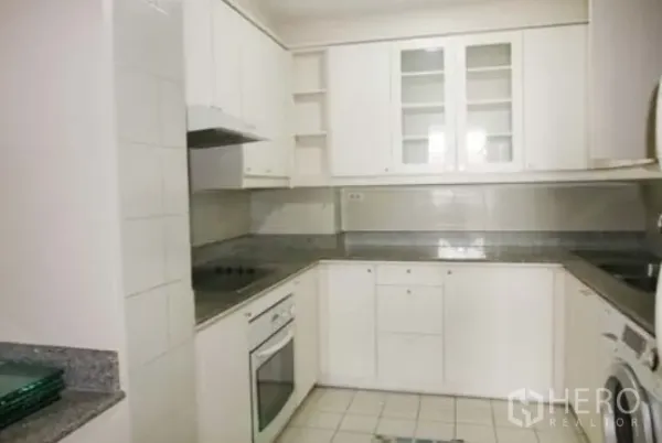 公寓 出租在Sathon, Bangkok - 封闭式U形厨房，白色橱柜，花岗岩台面，电炉、烤箱与洗衣机。