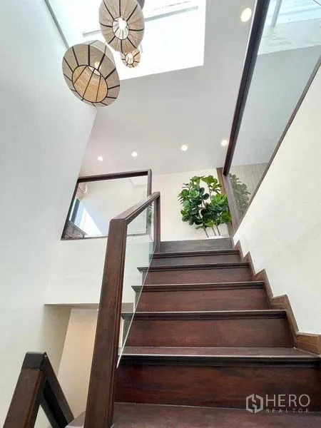 Detached House for rent in Bang Rak, Bangkok - Staircase with wooden treads, pendant lights and skylight.
