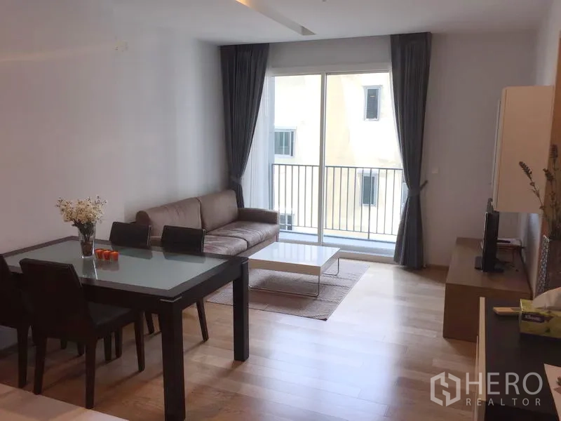 公寓 出租在Khlong Toei, Bangkok - 客餐厅一体，沙发与餐桌，推拉门通往小阳台。