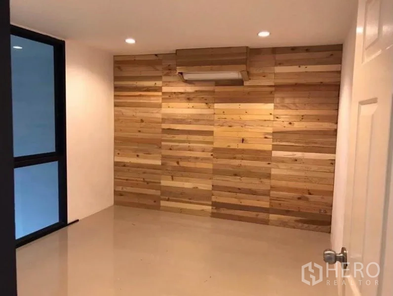 Townhouse for rent in Wang Thonglang, Bangkok - Room featuring a wooden accent wall, recessed lights, and tiled flooring.