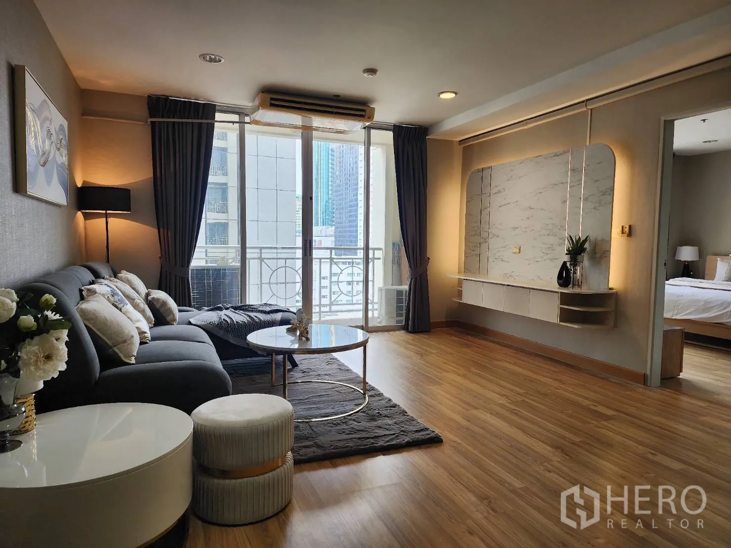 Condominium for rent in Watthana, Bangkok - Spacious lounge with balcony access and doorway leading to a bedroom.