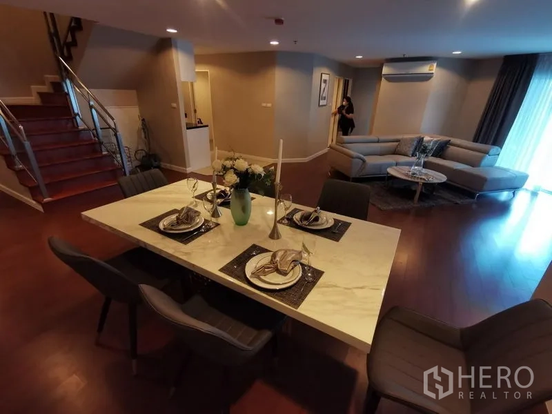 Condominium for rent or sale in Huai Khwang, Bangkok - Marble dining table set looking across to the lounge and stairs.