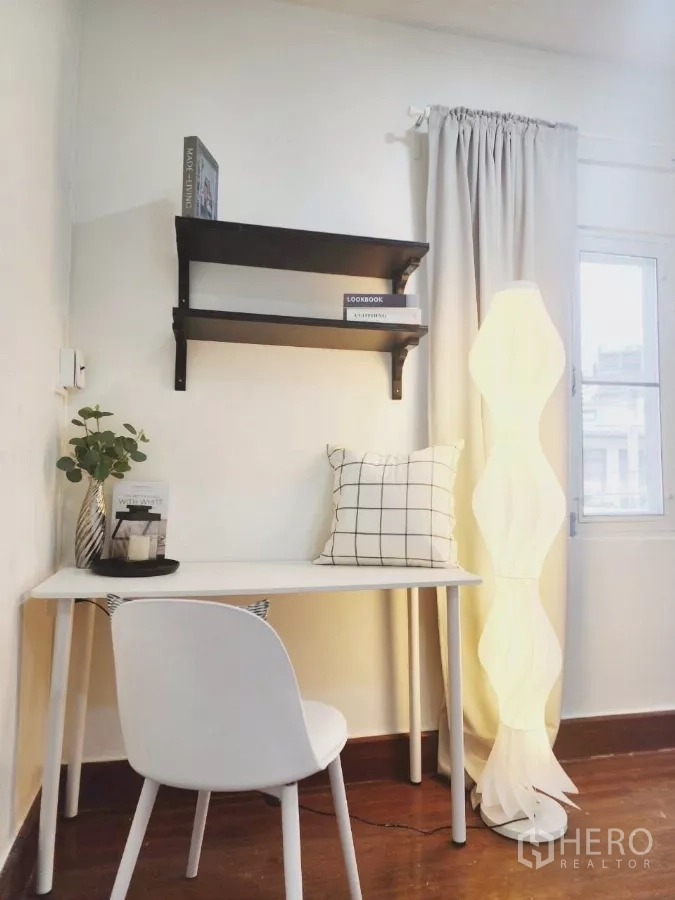 Detached House for rent in Chatuchak, Bangkok - Close-up of white writing desk with wall shelves and modern floor lamp.