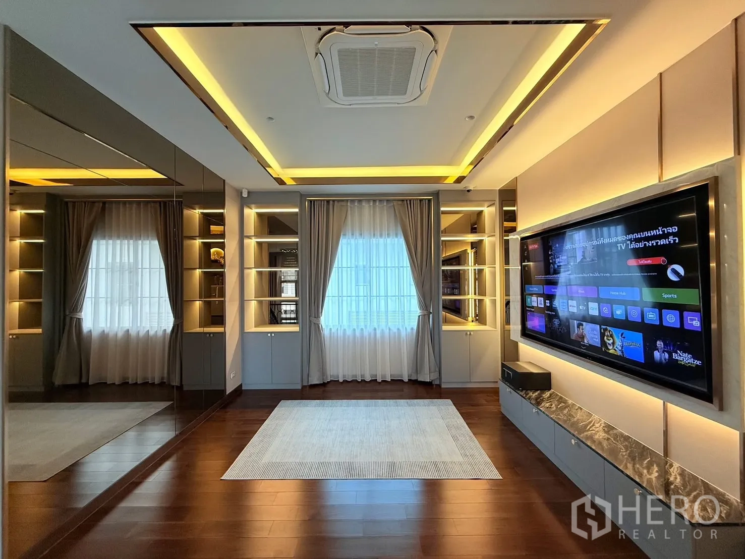 Detached House for rent or sale in Bang Phli, Samut Prakan - Media or family room with illuminated built-in shelves, large smart TV and cove lighting.