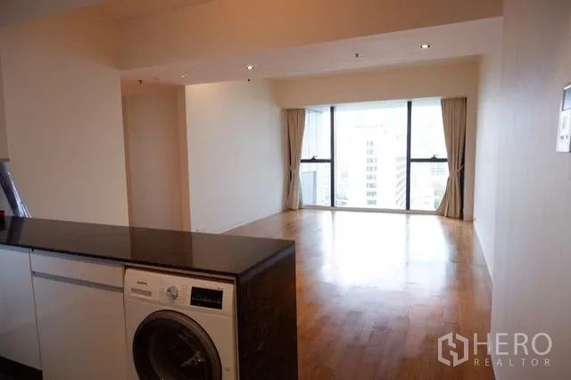 公寓 出售在Sathon, Bangkok - 开放式厨房吧台与室内洗衣机，连接客厅与景观窗。