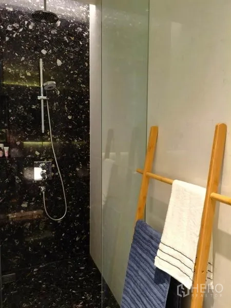 คอนโด ให้เช่าในKhlong Toei, Bangkok - ห้องอาบน้ำกระจก ฝักบัวเรนชาวเวอร์ ผนังหินสีเข้ม พร้อมบันไดไม้แขวนผ้า