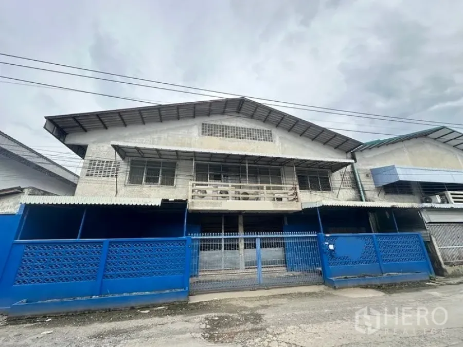 โรงงาน ให้เช่าในLam Luk Ka, Pathum Thani - ภาพด้านหน้าอาคารโรงงานพร้อมรั้วและประตูบานเลื่อน
