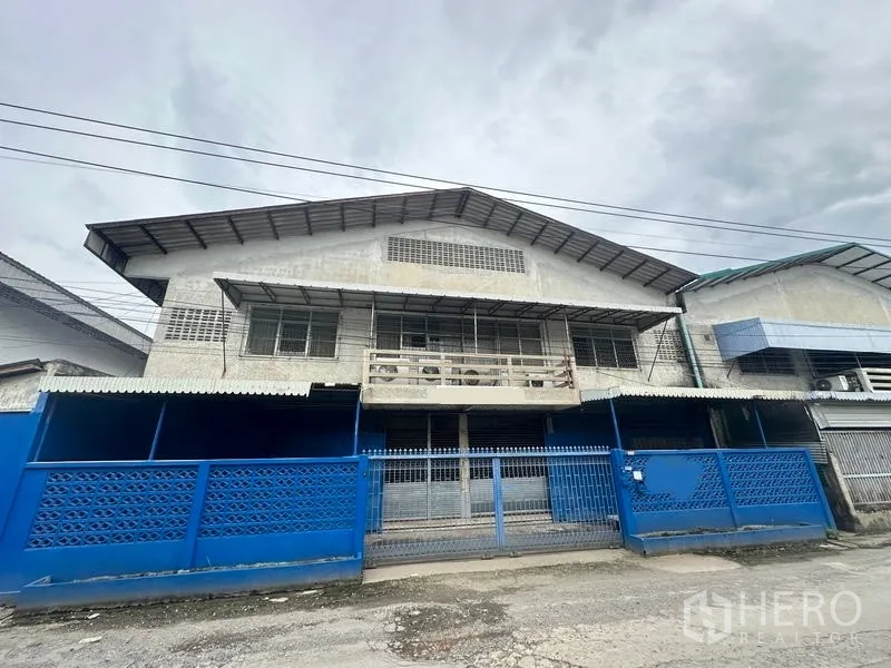 โรงงาน ให้เช่าในLam Luk Ka, Pathum Thani - ภาพด้านหน้าอาคารโรงงานพร้อมรั้วและประตูบานเลื่อน