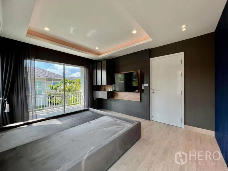 บ้าน ขายในBang Sao Thong, Samut Prakan - ห้องนอนหลักประตูบานเลื่อนออกระเบียง ผนังบิวท์อินทีวี และไฟฝ้าหลุม