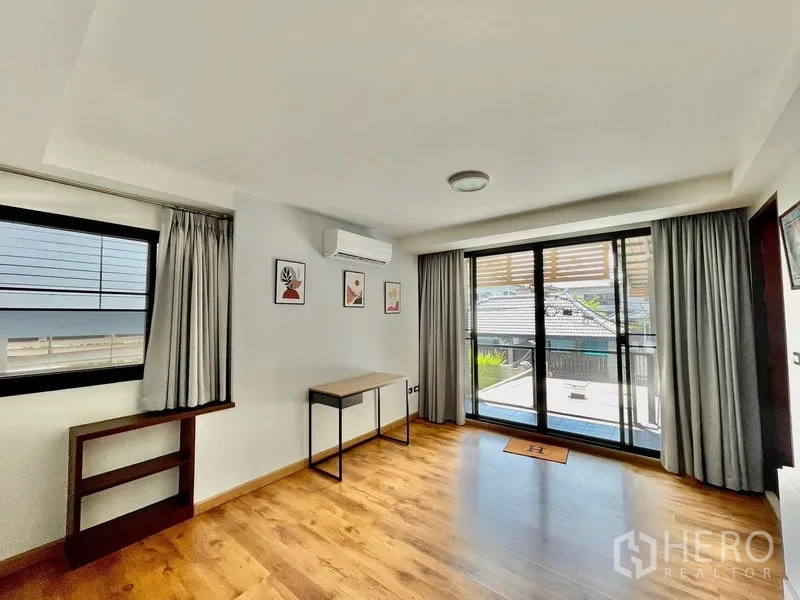 Townhouse for rent in Khlong Toei, Bangkok - Bright bedroom or study with desk, air-conditioning, and access to the balcony.