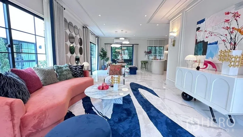 Detached House for rent or sale - Open-plan living area with a curved sofa, statement rug and wide windows flowing to the kitchen.