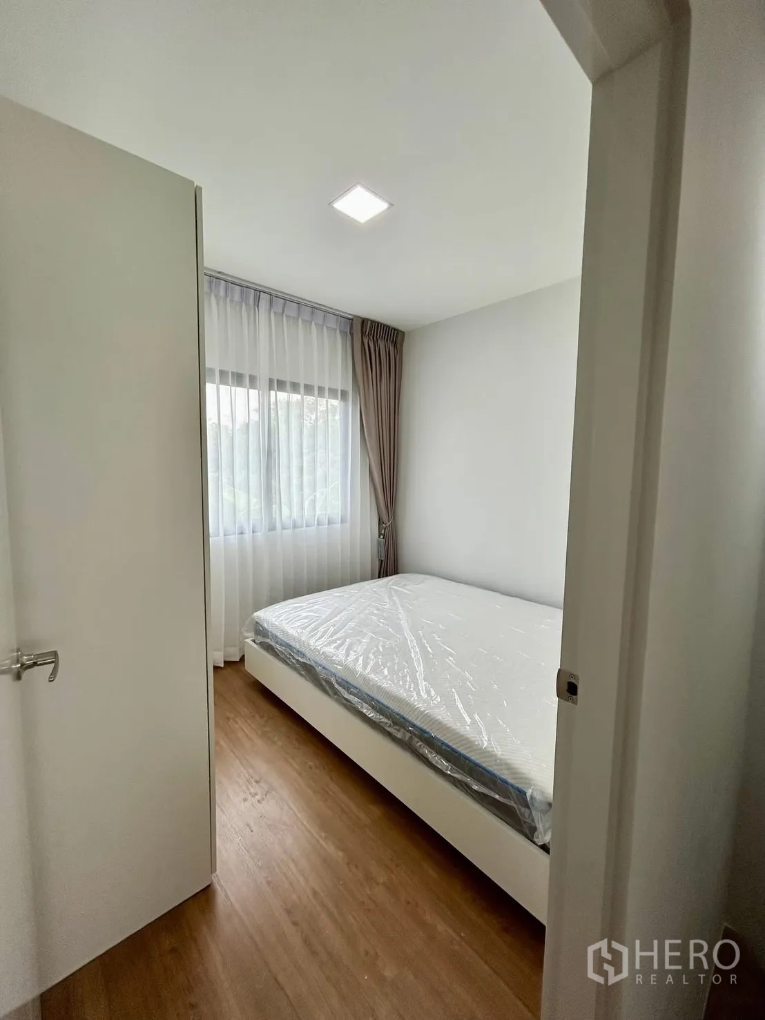 Townhouse for rent in Bang Phli, Samut Prakan - Cozy bedroom with double bed and sheer curtains.