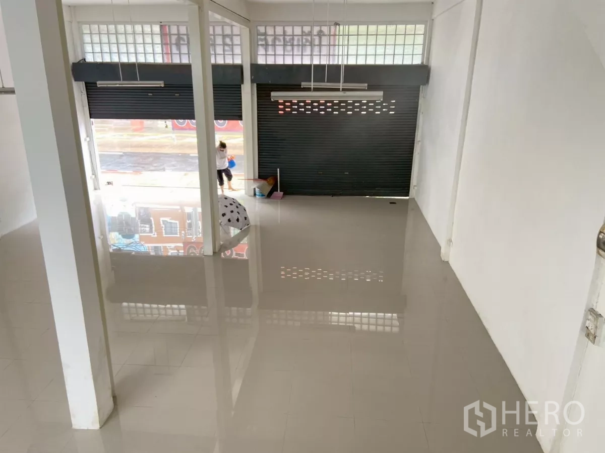 Shophouse for rent in Prawet, Bangkok - View from an upper level showing front roller shutters and glass-block windows bringing natural light.
