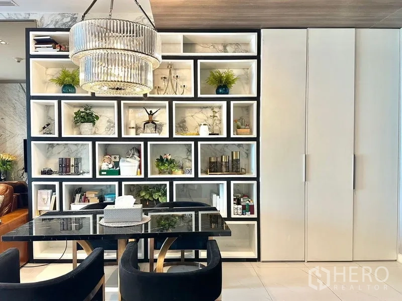 Condominium for rent in Pathum Wan, Bangkok - Decorative shelving wall behind dining table under statement chandelier.