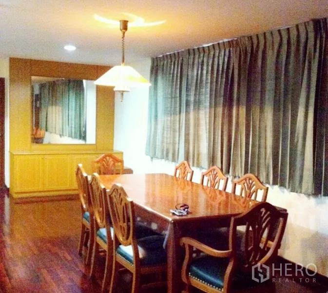 Condominium for rent in Watthana, Bangkok - Bright dining room with long drapes, wall mirror, and built-in buffet cabinet.