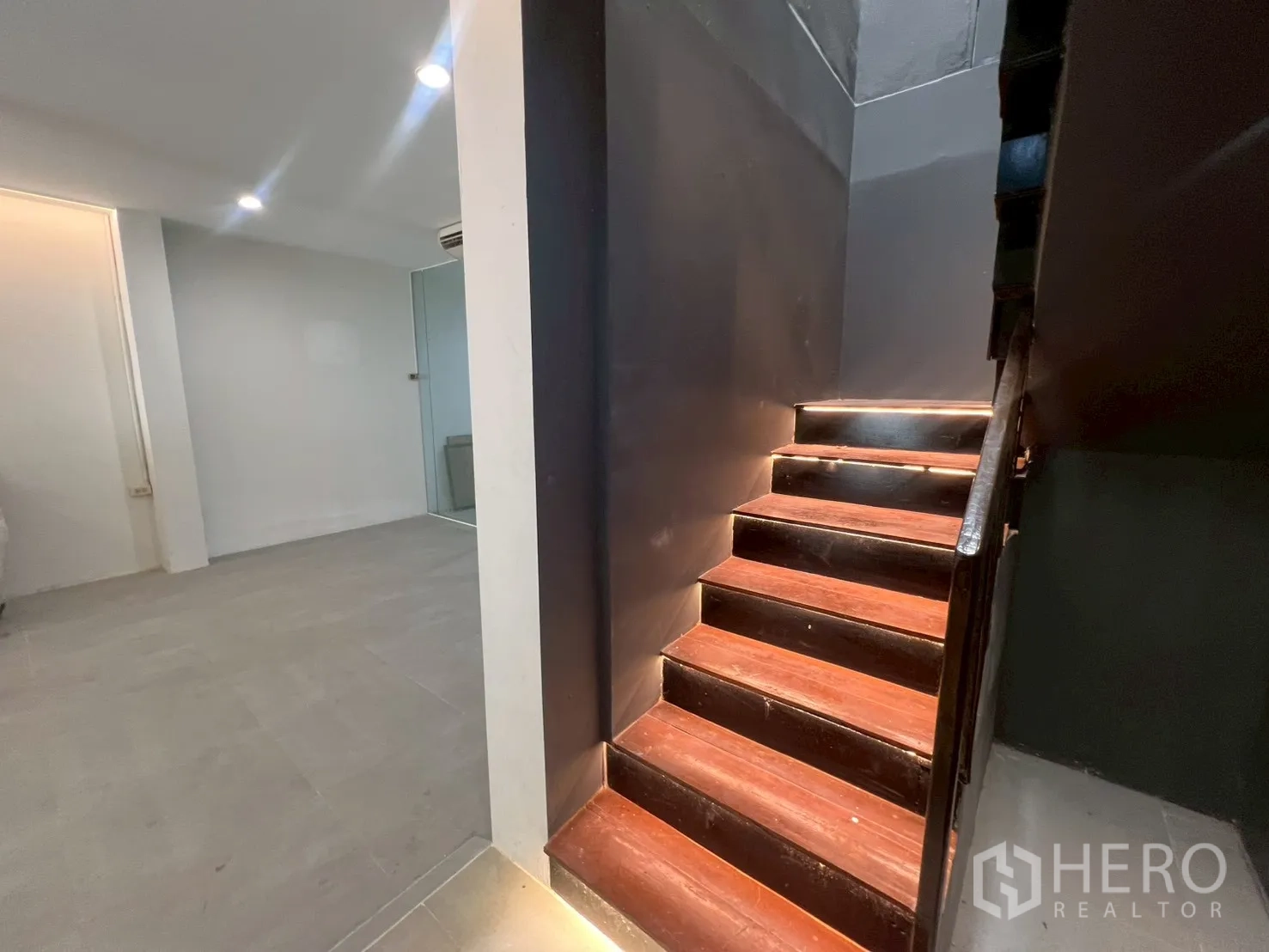 Home Office for rent in Watthana, Bangkok - Close-up of wooden staircase with LED step lights leading to the upper floor.