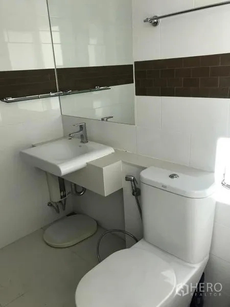 Condominium for rent or sale - Bright bathroom with vanity, mirror and modern toilet.