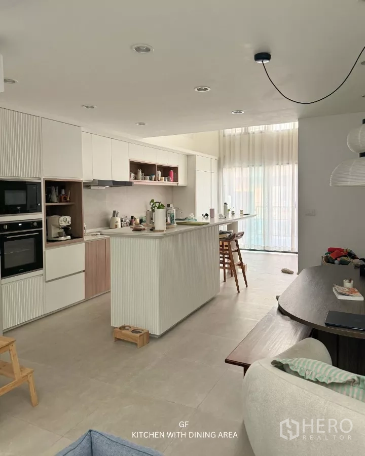 ทาวน์เฮาส์ ให้เช่าในSuan Luang, Bangkok - ครัวและพื้นที่รับประทานอาหารพร้อมไอส์แลนด์ต่อเนื่อง เครื่องใช้บิวท์อิน และผ้าม่านสูง