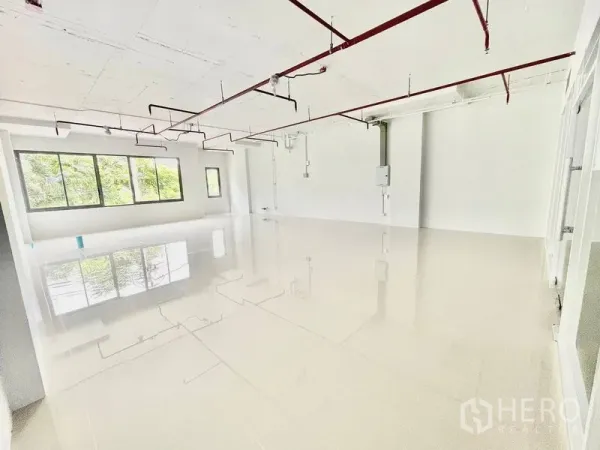 พื้นที่ขายปลีก ให้เช่าในKhlong Toei, Bangkok - พื้นที่ค้าปลีกแบบโอเพนสเปซสว่าง พื้นกระเบื้องเงา หน้าต่างบานกว้าง และท่อเพดานสีแดงแบบโชว์งานระบบ