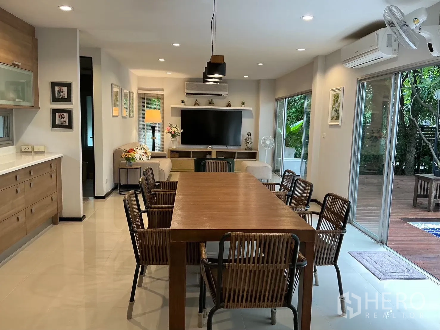 บ้านเดี่ยว for sale in Suan Luang, Bangkok - พื้นที่รับประทานอาหารและนั่งเล่นแบบเปิดโล่ง โต๊ะไม้ยาวและประตูกระจกบานเลื่อน