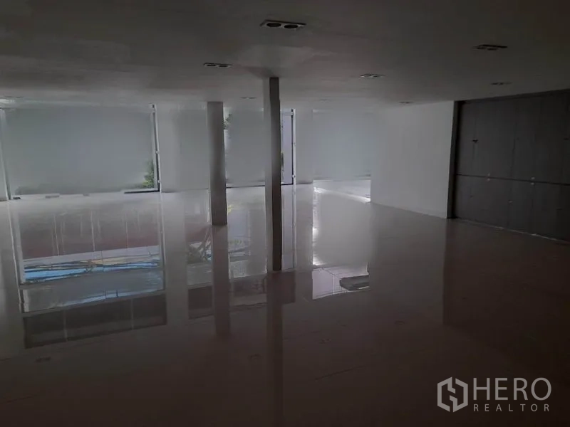 零售空间 出租在Ratchathewi, Bangkok - 夹层区域，磨砂窗、瓷砖地与结构立柱，布局灵活。