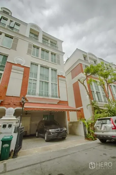 Townhouse for rent in Watthana, Bangkok - Four-storey Thonglor townhouse exterior with brick accents and covered carport in Watthana, Bangkok.