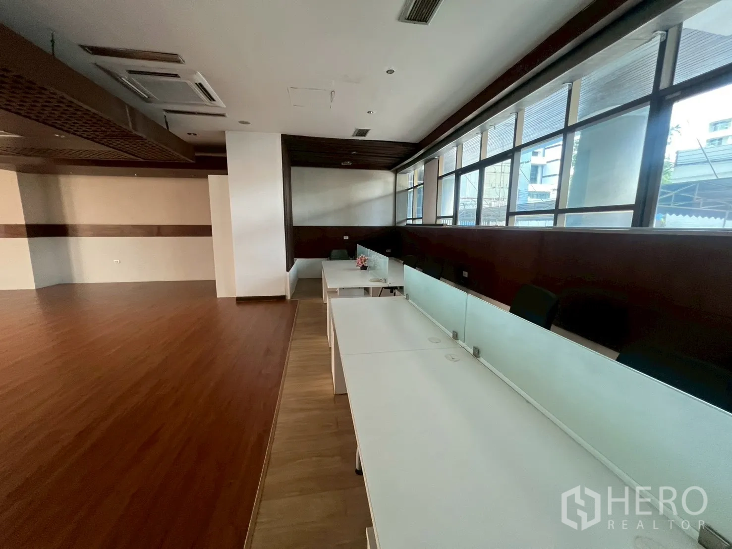 พื้นที่ขายปลีก ให้เช่า - พื้นที่ทำงานริมหน้าต่างโต๊ะสีขาวต่อเนื่อง พร้อมฉากกระจกฝ้า