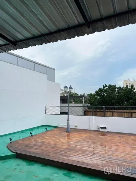 Townhouse for rent in Phaya Thai, Bangkok - Rooftop terrace featuring a raised wooden deck, partial roof cover and open city views.