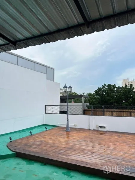 Townhouse for rent in Phaya Thai, Bangkok - Rooftop terrace featuring a raised wooden deck, partial roof cover and open city views.