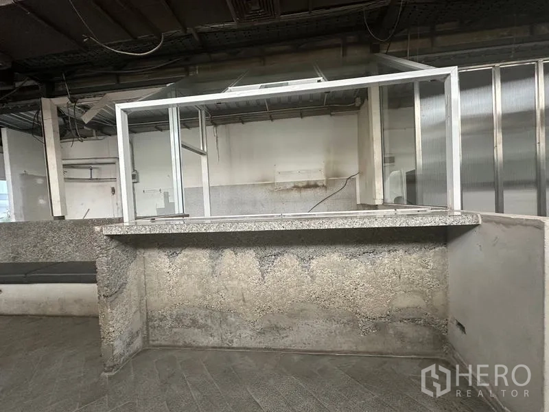 零售空间 出租在Bang Rak, Bangkok - 混凝土服务吧台，配铝合金玻璃窗与粗糙质感表面。