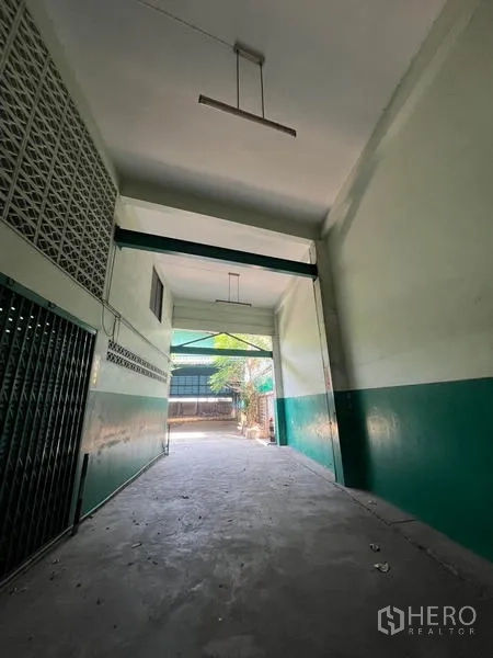 คลังสินค้า ให้เช่าในBang Kho Laem, Bangkok - ทางวิ่งเพดานสูงเชื่อมสู่ลานด้านหลัง ผนังทาสีเขียว-ขาว